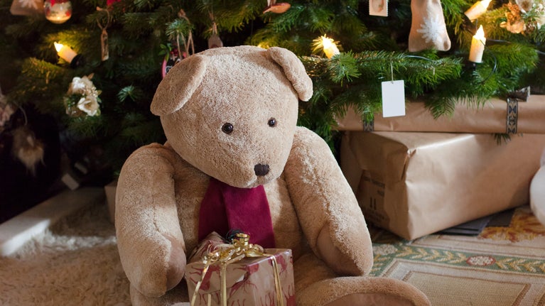 Teddy bear and presents by the Christmas tree